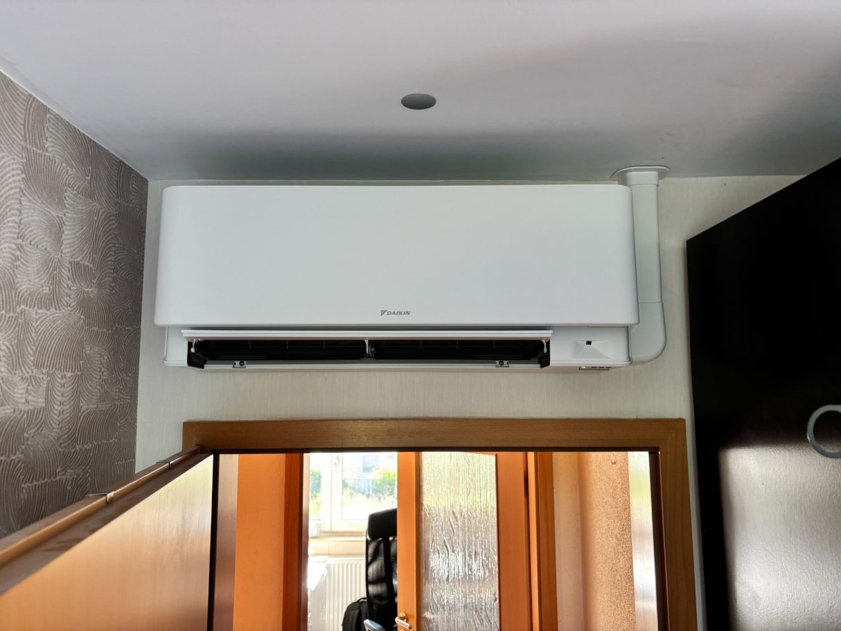 Wandklimaanlage von Daikin über einer Tür im Schafzimmer.