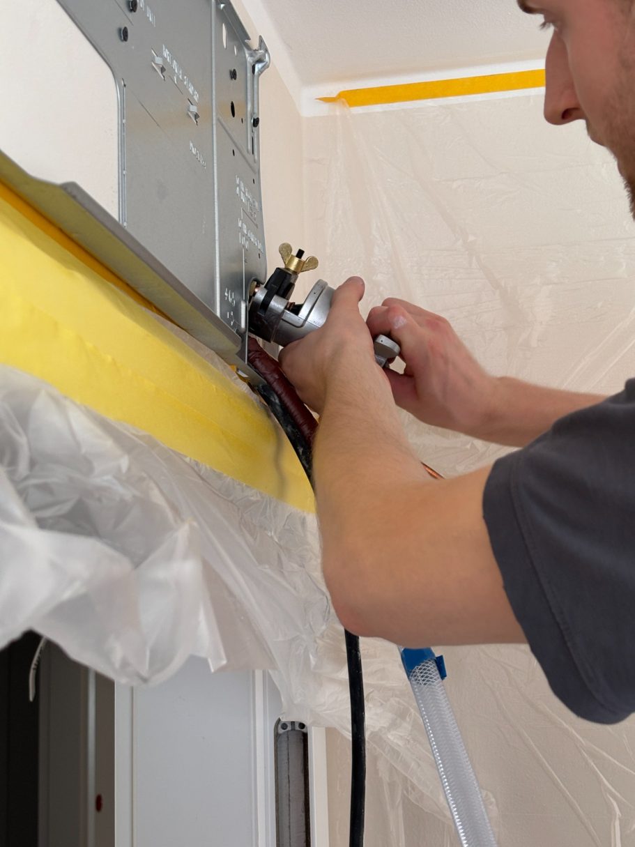 Hand eines TRILUC Kältetechnikers, der Kupferrohr mittel Börtelglocke bearbeitet.